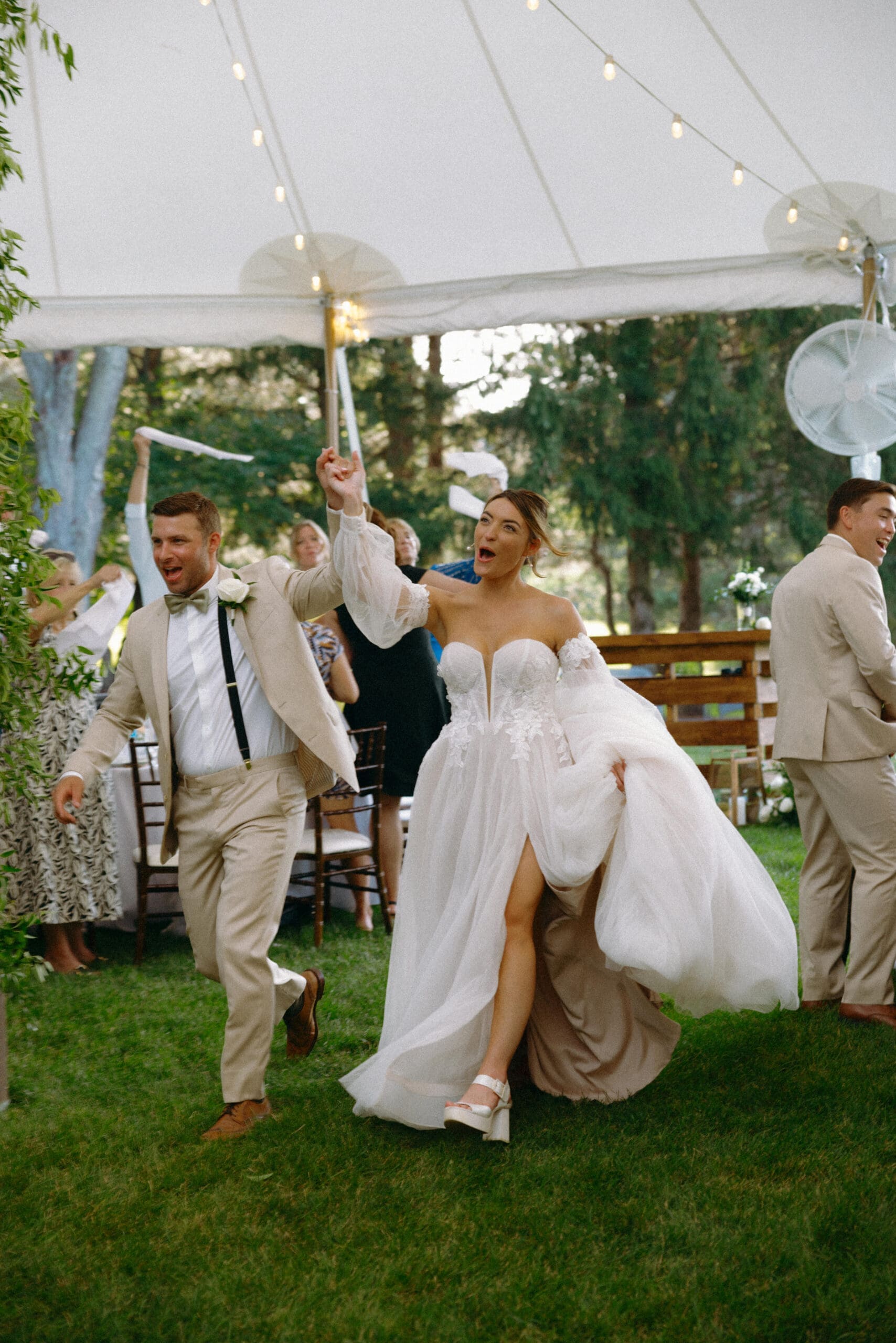 Bride and groom making their wedding reception entrance under a backyard tent at a family farm wedding in Grayslake Illinois during a summer wedding celebration.
